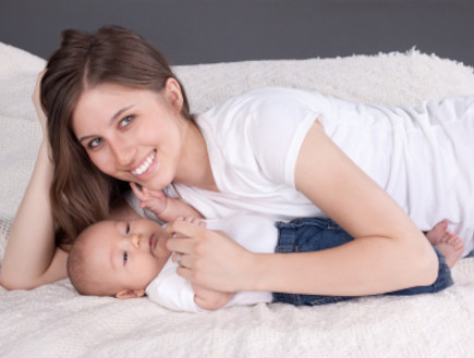 אמא שוכבת לצד תינוק (צילום: istockphoto)