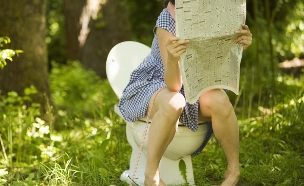 אישה בשירותים קוראת עיתון (צילום: אימג'בנק / Thinkstock)