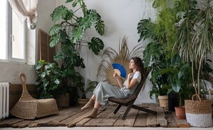 אישה מצננת את עצמה  עם מניפה, עציצים גדולים (צילום: DimaBerlin, SHUTTERSTOCK)